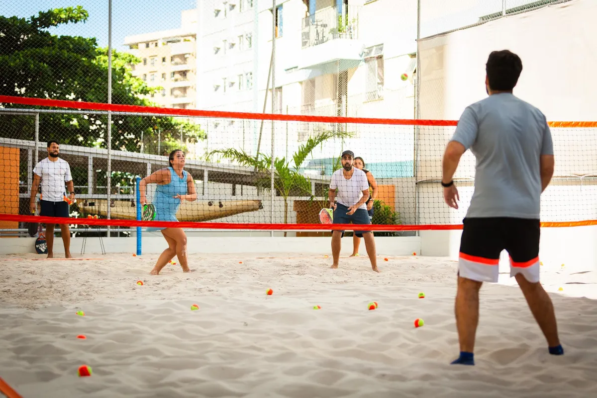 Turma acompanha a bola durante uma atividade na quadra da Arena Aldeia